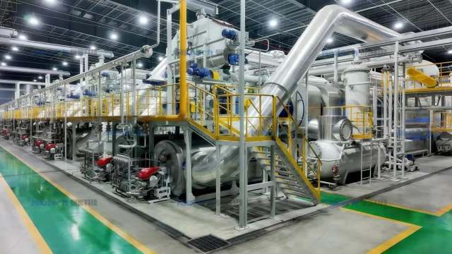 A large industrial facility with machinery, pipes, and staircases for processing.