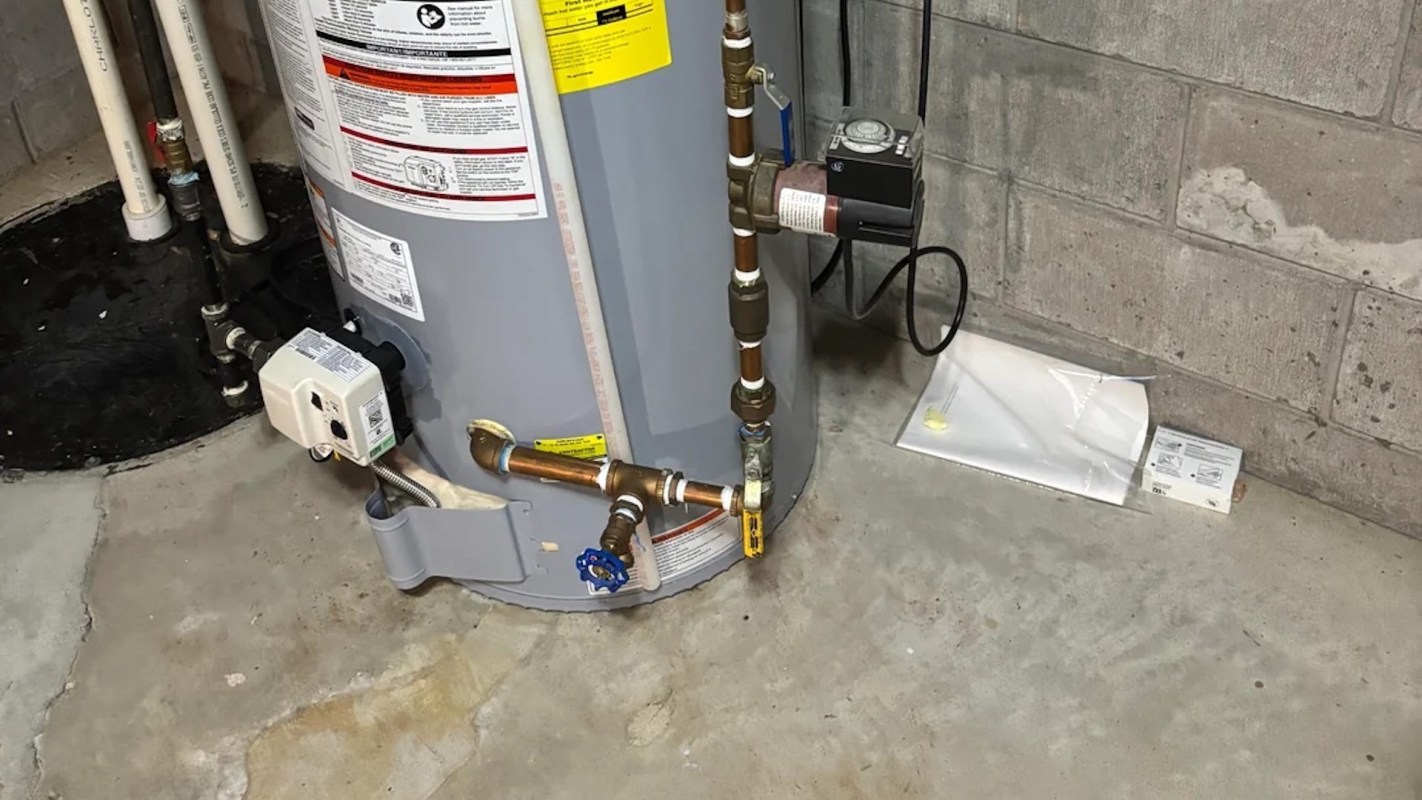 A water heater with connected pipes and valves in a basement setting.