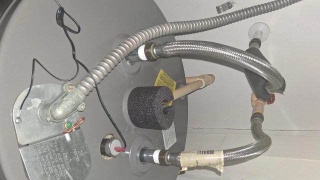 A close-up of plumbing connections for a water heater.