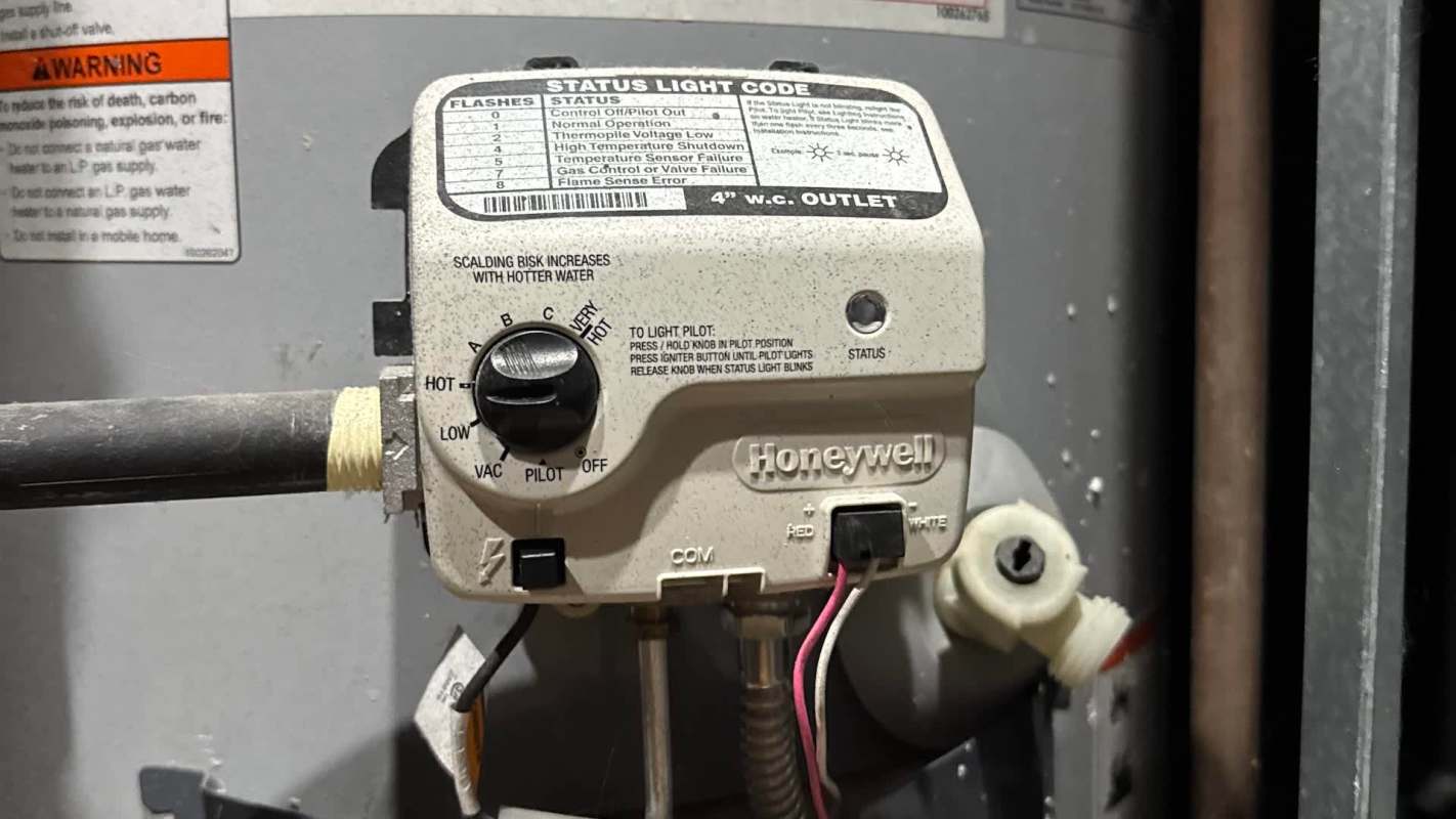 A Honeywell gas control valve with various settings and status indicators, mounted on a water heater.