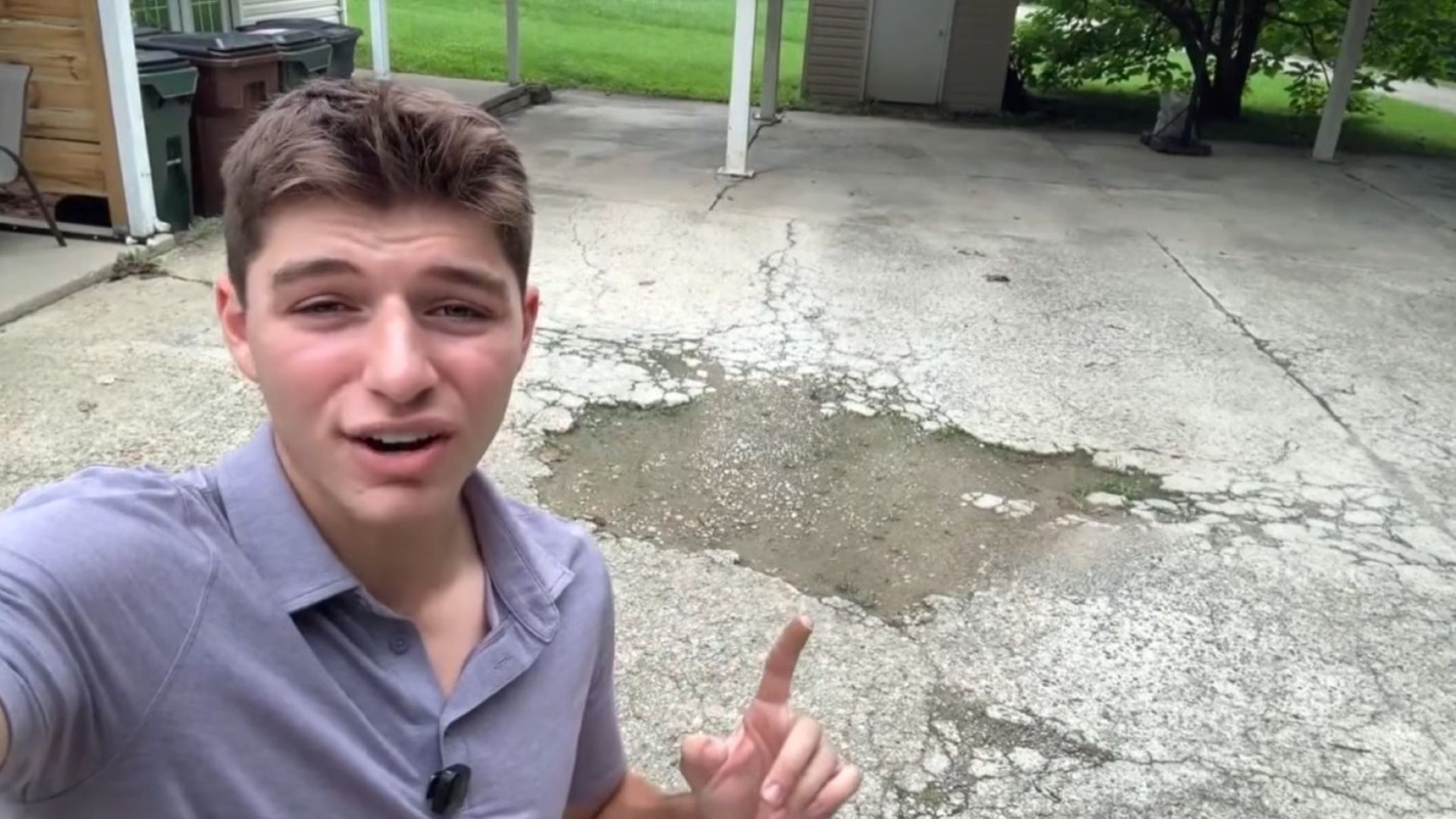 A person pointing to damaged concrete.