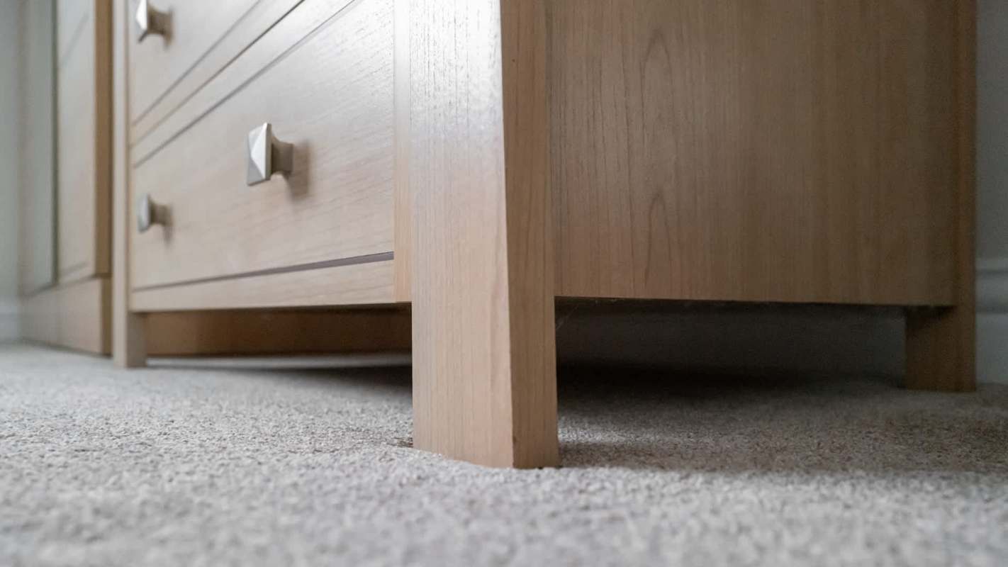 A wooden cabinet with drawers on a carpeted floor.
