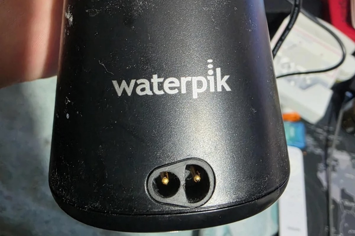 A close-up of a Waterpik device with visible electrical connectors.