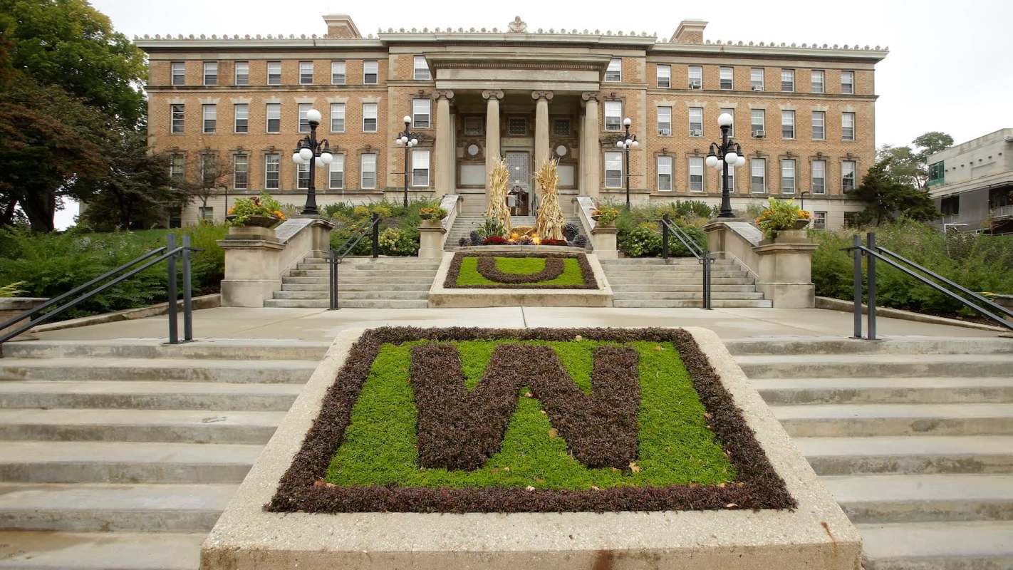 A building with architectural columns and landscaped steps featuring greenery and decorative plant arrangements.