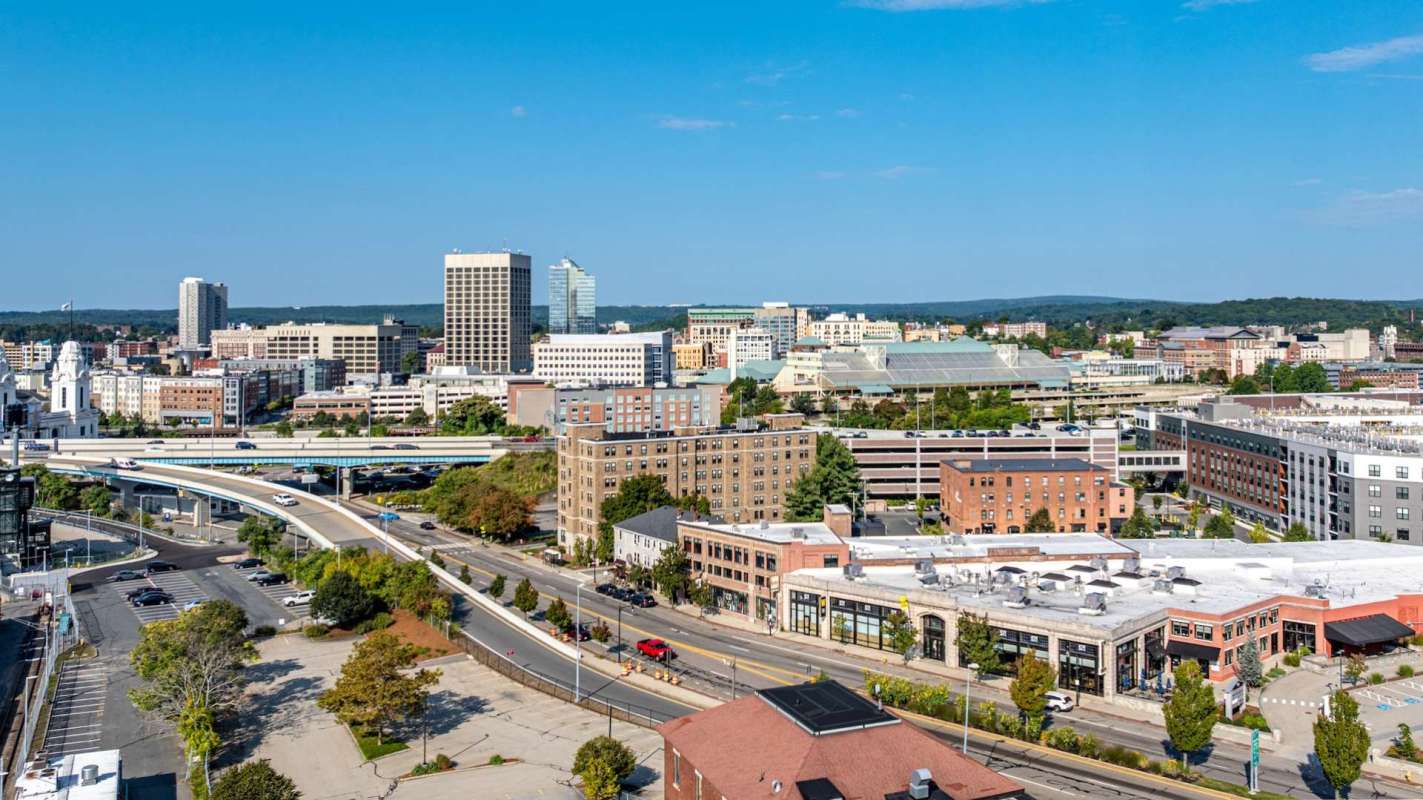 Downtown Worcester, Massachusetts, skyline featuring various buildings, roads, and a clear blue sky.