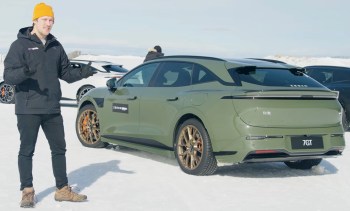 A man stands beside an olive green Zeekr 7GT electric car on snow, with additional cars in the background.