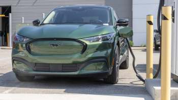 A green Ford Mach-E at a charging station.