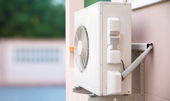An outdoor air conditioning unit mounted on a wall.