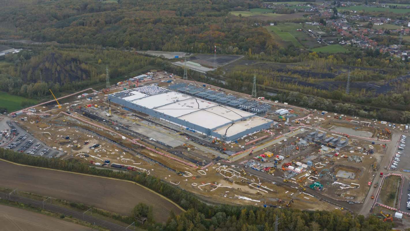 A construction site featuring a large building and surrounding machinery.