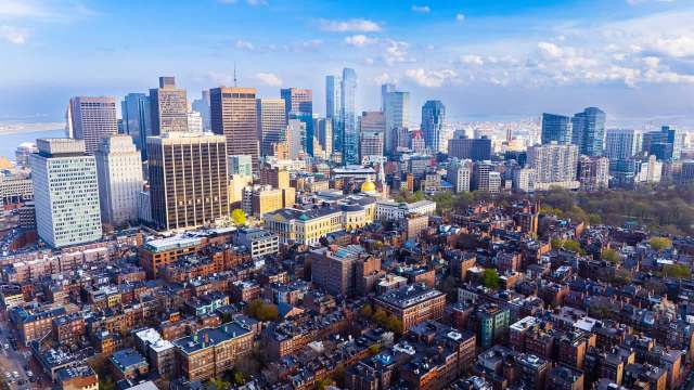 Aerial view of a city skyline with a mix of modern skyscrapers and historic buildings.