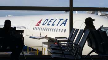 A Delta plane at an airport gate.