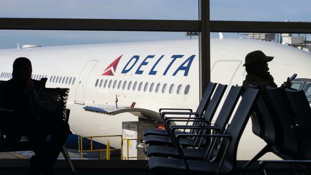 A Delta plane at an airport gate.