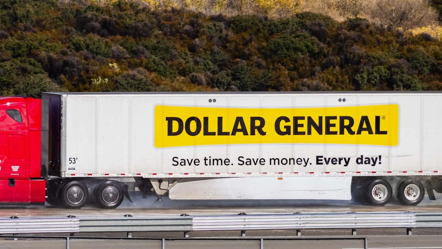 A red truck with a trailer displaying the Dollar General logo on the side.