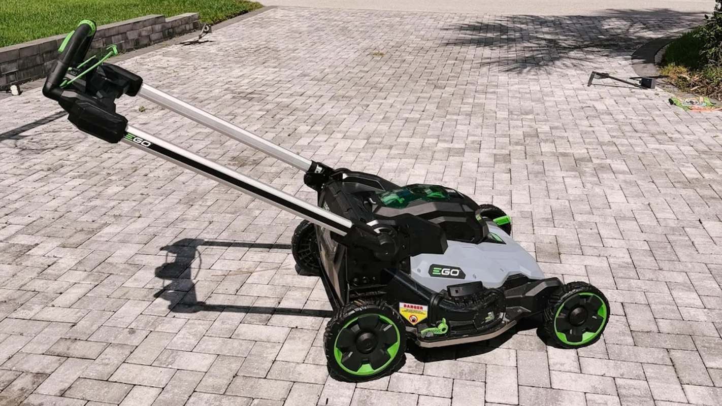An electric EGO lawn mower on a interlocking brick driveway.