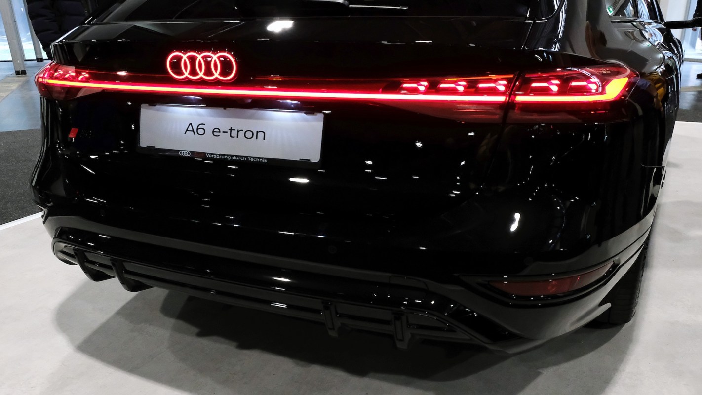 A black Audi A6 e-tron with illuminated rear lights.