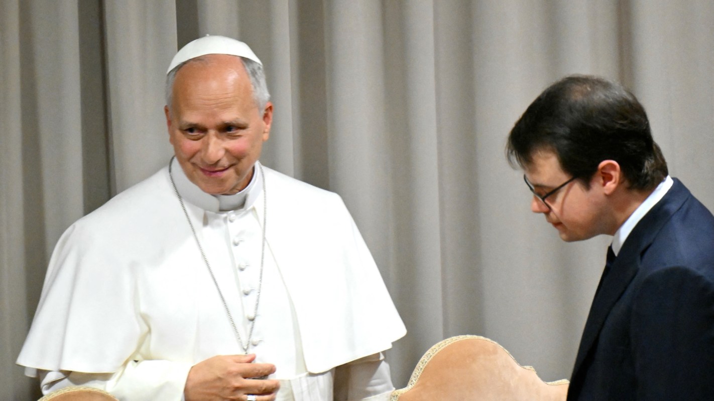 Pope Leo XIV speaks with Anthropic's Chris Olah in a room with gray curtains.
