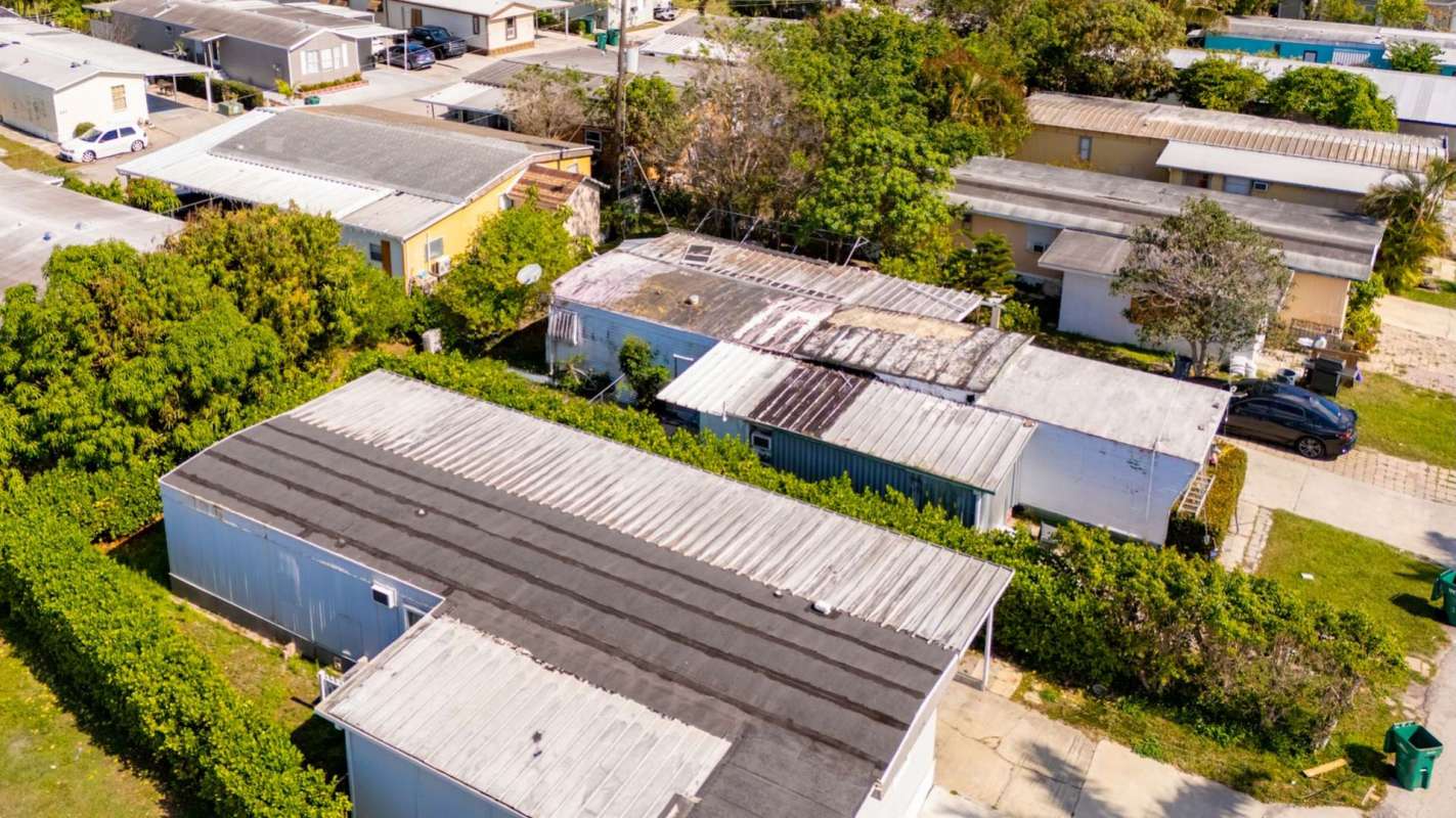 Aerial view of a residential area with mobile homes and greenery.