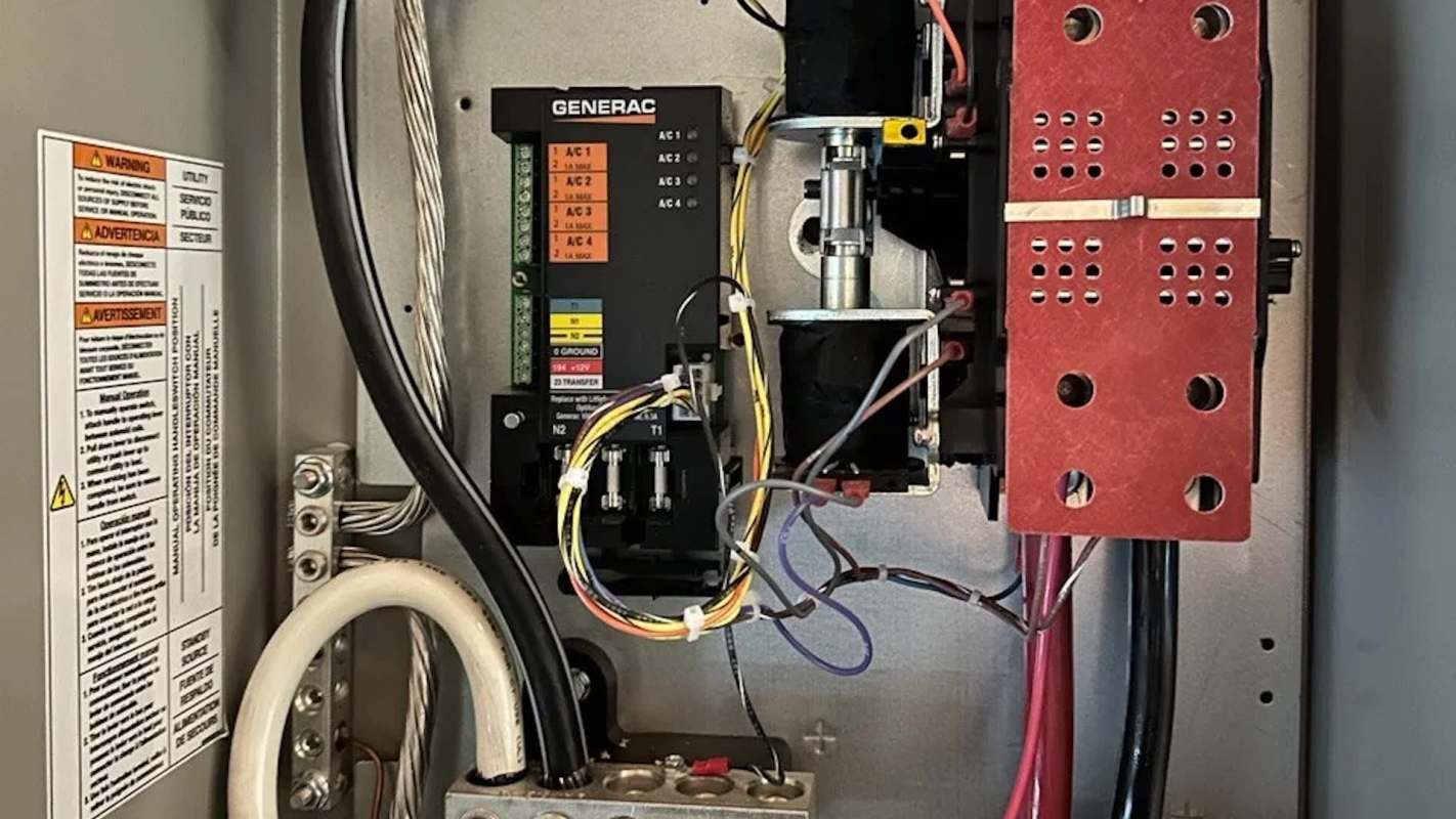An electrical control panel with wiring, breakers, and a warning label.