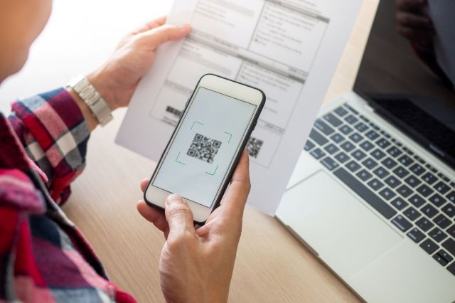 A person scans a QR code with a smartphone.