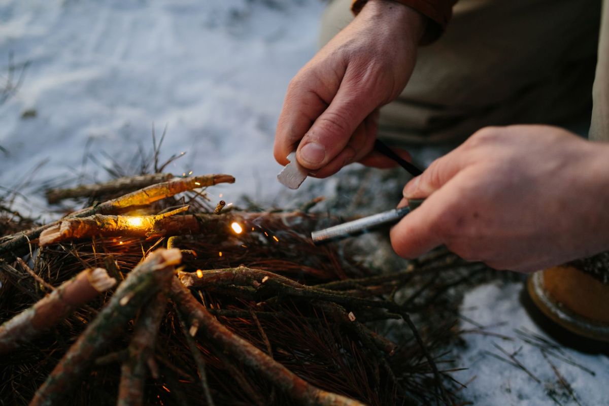 A person starting a fire with a ferro rod.