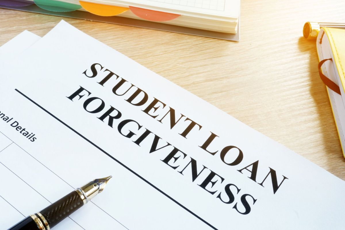 A paper application for student loan forgiveness sits on a desk with a pen