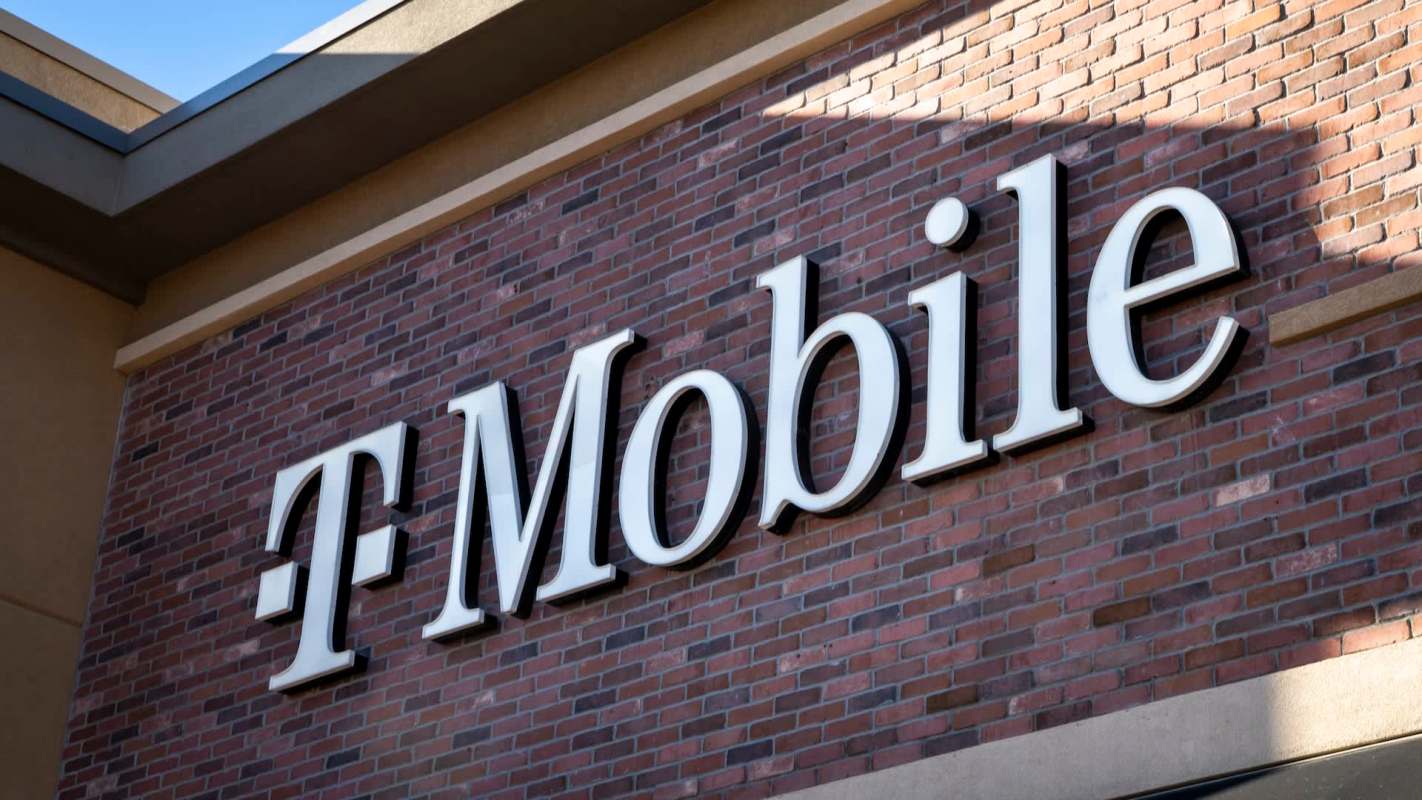 A T-Mobile sign on a brick wall.