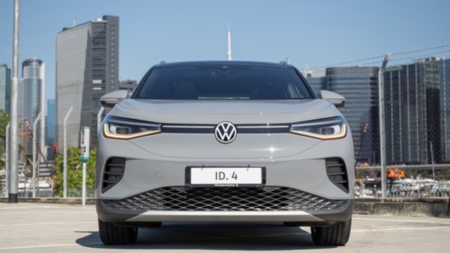 A Volkswagen ID.4 parked with a city skyline in the background.