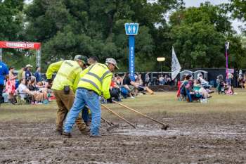 Workers raking mud at Austin City Limits.
