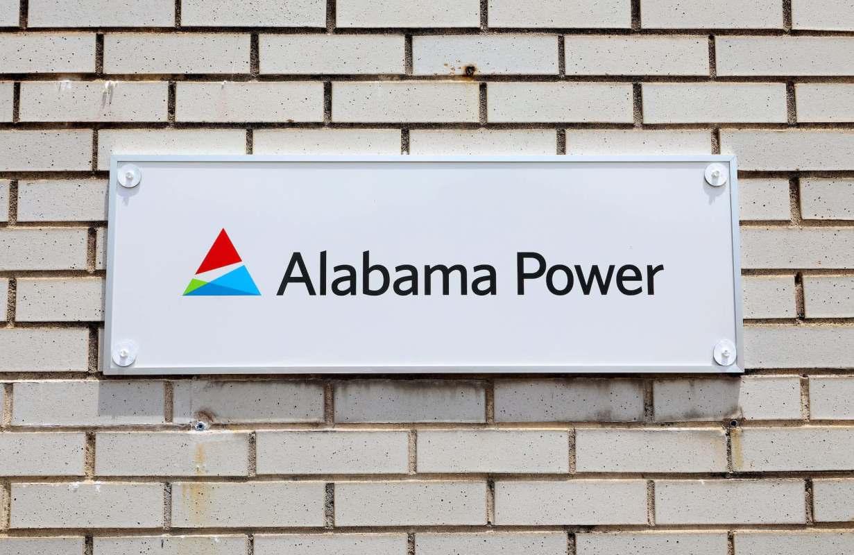 A sign for Alabama Power mounted on a brick wall.