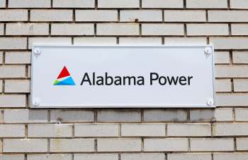 A sign for Alabama Power mounted on a brick wall.