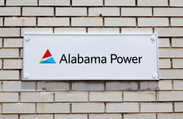 A sign for Alabama Power mounted on a brick wall.