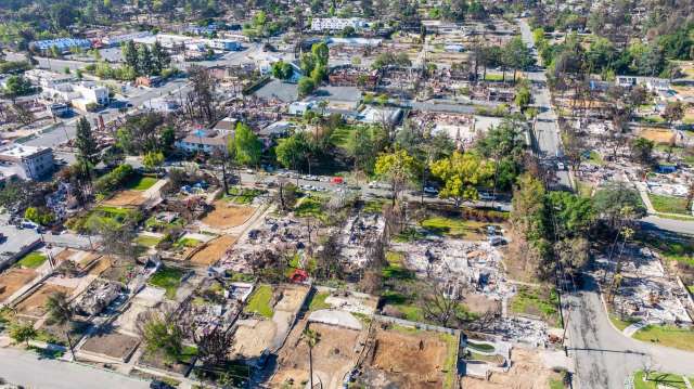 An aerial view of an Altadena, California, neighborhood showing damaged homes alongside intact structures and roads.