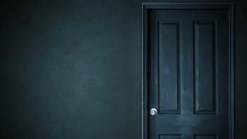 A dark door on a textured wall.