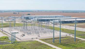An industrial area featuring a power substation and a large modern building in an open landscape.