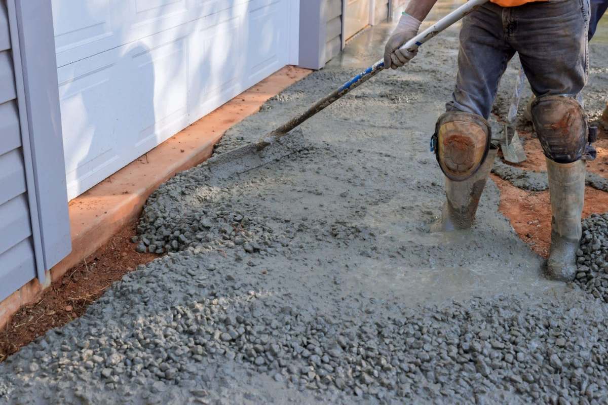 A worker laying concrete.