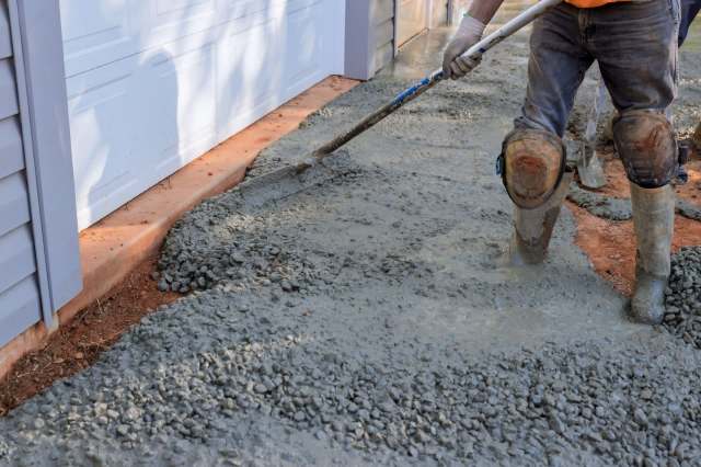 A worker laying concrete.