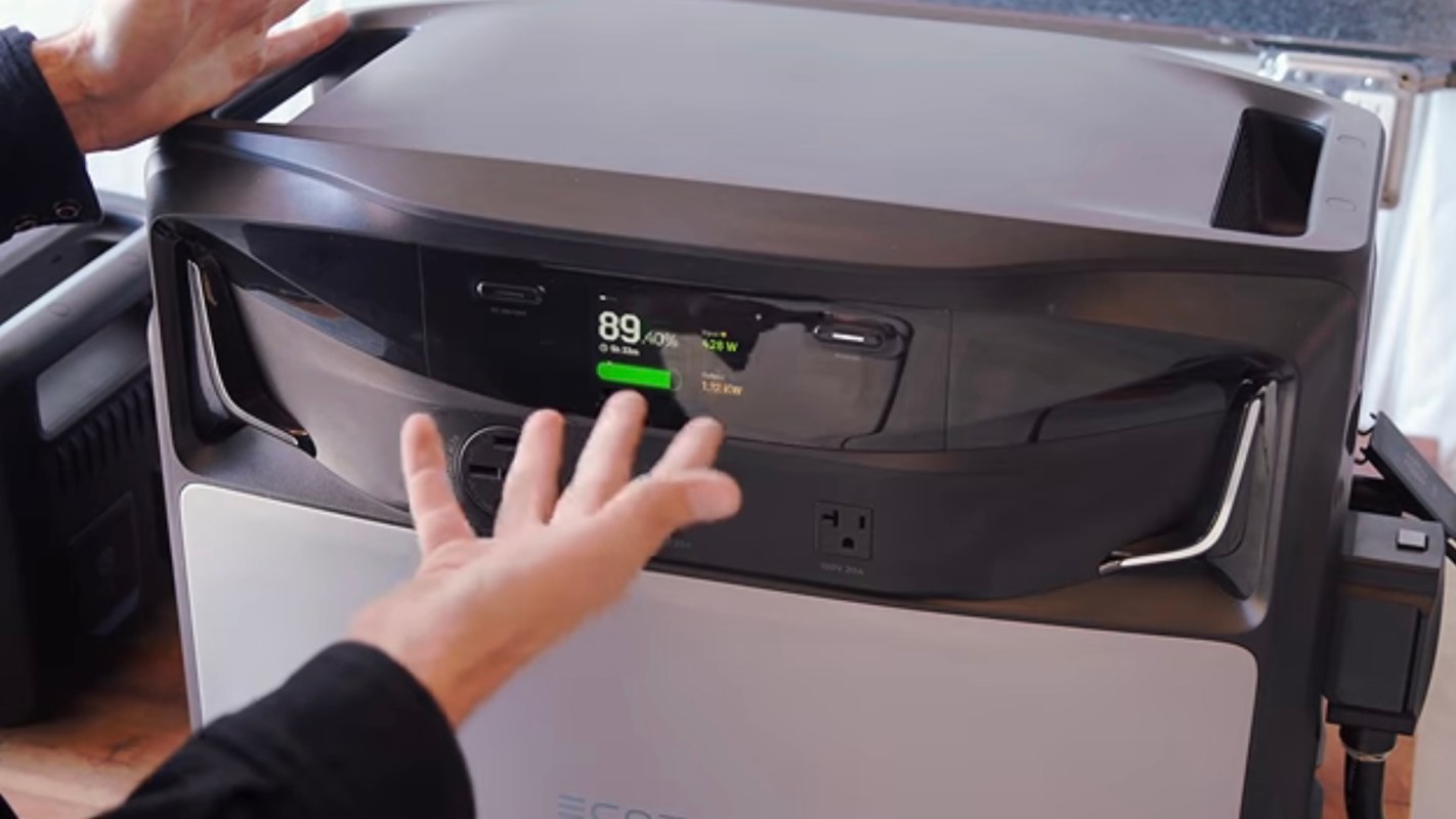 A hand interacts with the control panel of a power station displaying battery percentage and power usage.