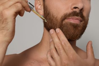 A man applying beard oil.