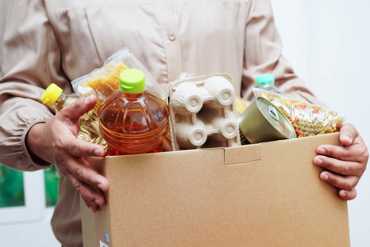 A person holding a box of food.