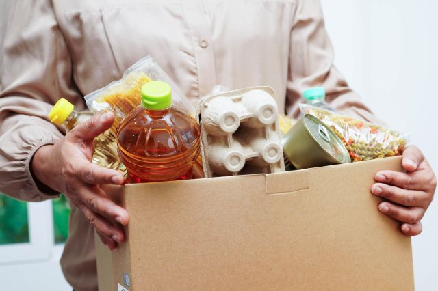 A person holding a box of food.