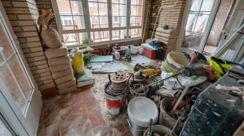 A cluttered room filled with construction materials, tools, and equipment.
