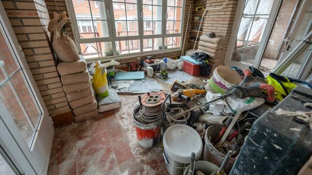A cluttered room filled with construction materials, tools, and equipment.