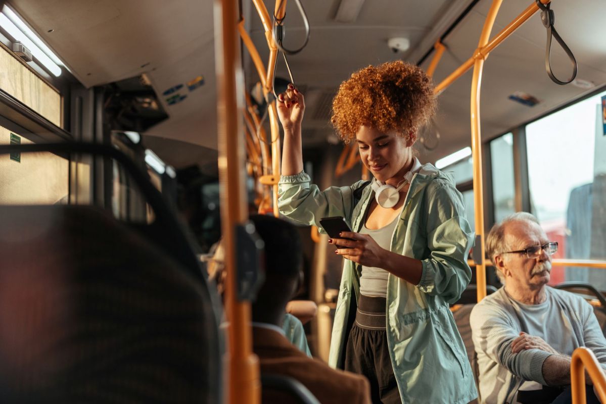 A woman standing on a bus.
