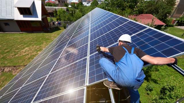 A worker installing solar panels.