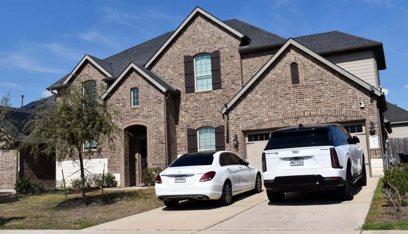 A large house with two cars in the driveway.