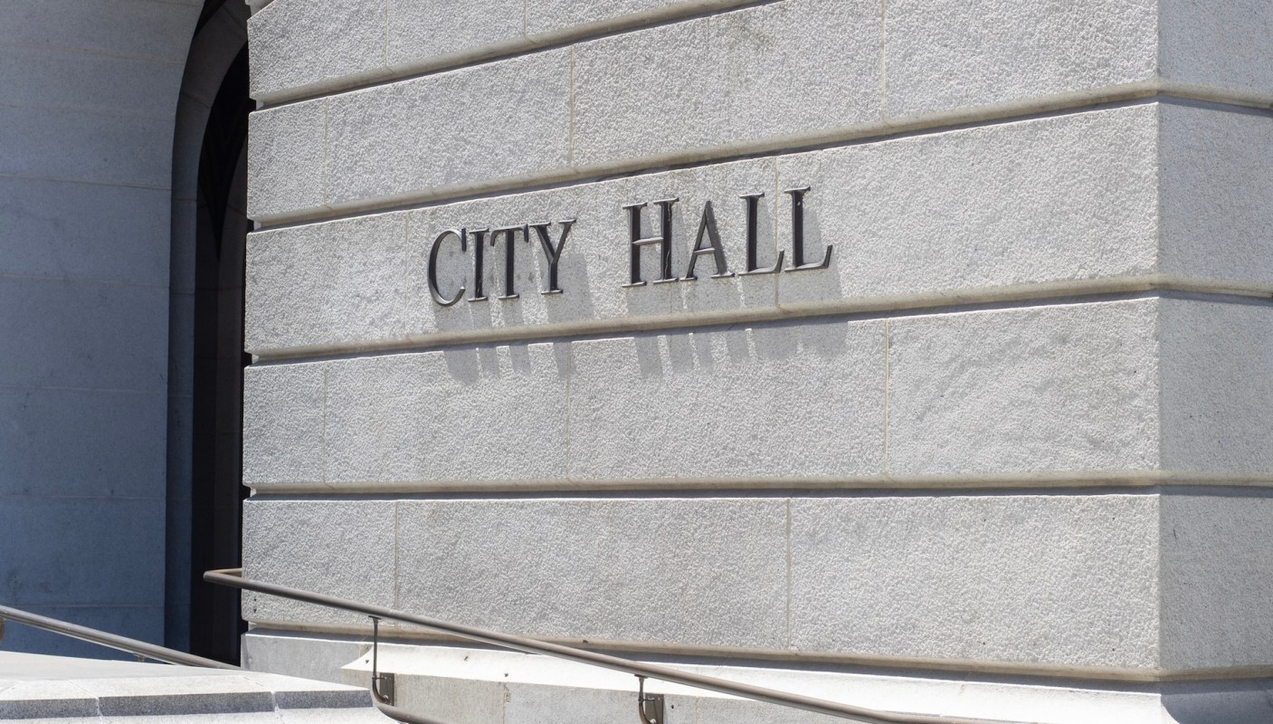The words "CITY HALL" are displayed on the exterior of a building.