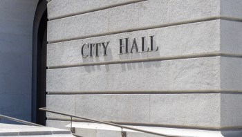 The words "CITY HALL" are displayed on the exterior of a building.