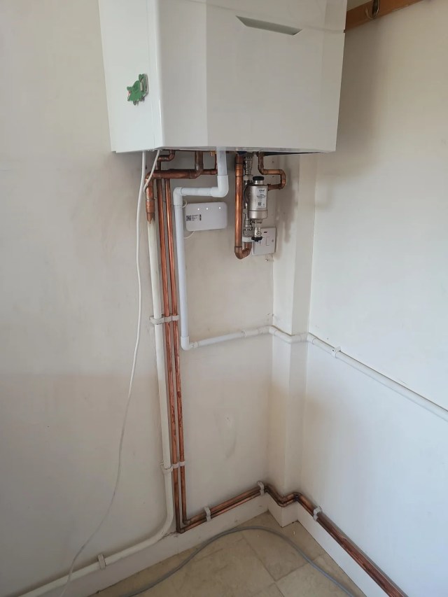 A boiler with a hanging electrical cord.
