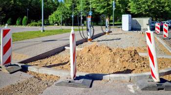 A construction area featuring electric vehicle charging stations and cones.