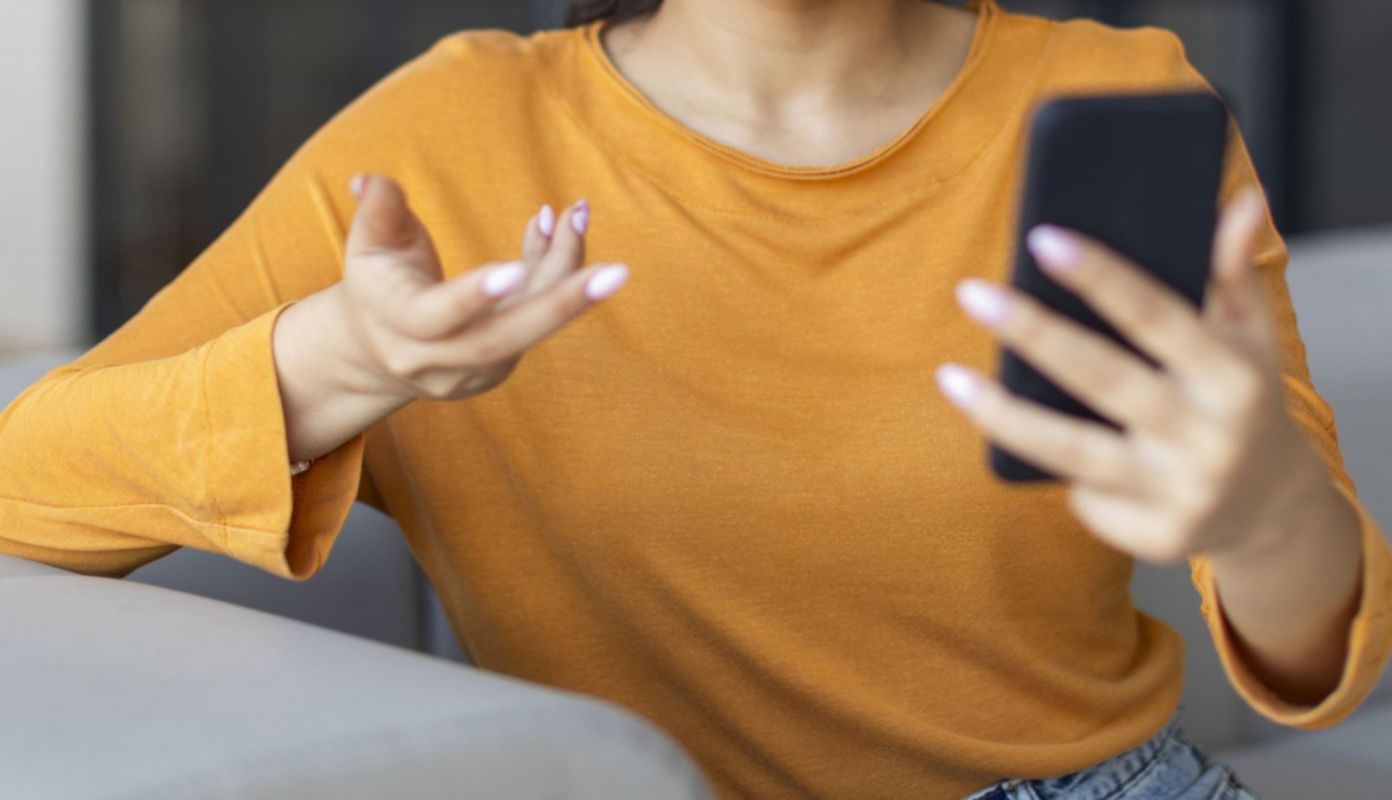 A frustrated person looking at a phone.